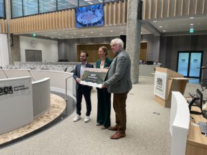 Alex Ouwehand namens Natuur en Milieufederatie Zuid-Holland overhandiigt foambord met petitiehandtekeningen Red het Groene Hart aan Anne Koning en Sinan Özkaya